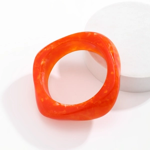 Macro view of orange translucent acrylic bracelet with elegant marble texture