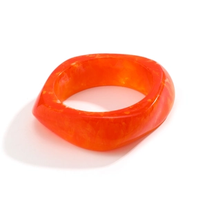 Detail of chunky orange marble resin bangle with irregular geometric acrylic texture