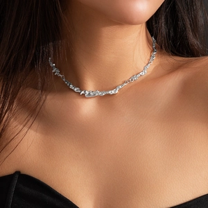 Close-up of irregular liquid metal lava choker necklace on model neck in silver finish