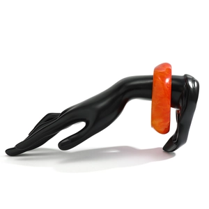 Detailed macro view of an orange marble acrylic bangle on a professional black hand display