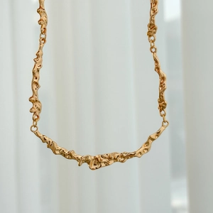 Detail of liquid gold texture and irregular lava patterns on this gold metal choker