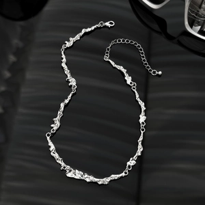 Detail of silver irregular lava choker with adjustable lobster clasp on black background