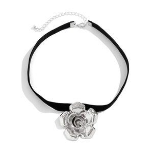Collana girocollo vintage in velluto con grande ciondolo a rosa d'argento su sfondo bianco