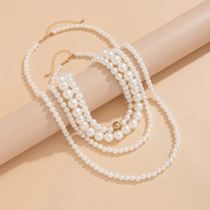 Detalle de collar de perlas de varias capas con cierre dorado sobre fondo minimalista