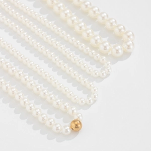 Detalle de collares de perlas barrocas multicapa de varios tamaños con acabado brillante