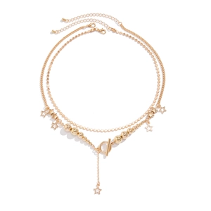 Detail of gold double-layer necklace with star pendants, round beads and OT toggle clasp