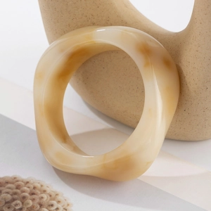 Detailed macro shot of irregular marbled acrylic resin open bangle with a smooth finish