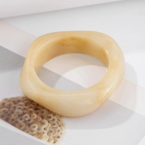 Detail shot of chunky cream resin ring with subtle marble texture and geometric shape
