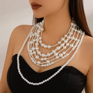 Primer plano de collar de perlas barrocas multicapa en modelo con vestido negro