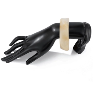 Detail of chunky cream acrylic geometric bracelet on a sleek black hand mannequin