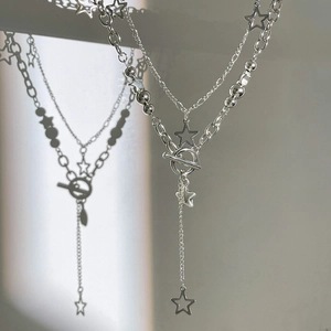 Detail of silver double-layered chain necklace with hollow star pendants and OT buckle