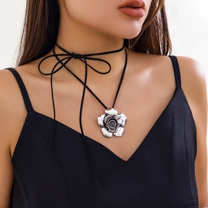 Dettaglio del ciondolo a rosa vintage con texture su un laccio nero da annodare