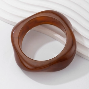 Detailed close-up of chunky irregular amber resin bangle with marbled wave pattern