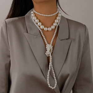 Detalle de collar de perlas barrocas de tres capas con perlas blancas de varios tamaños