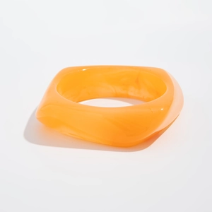 Detail of a wide square orange translucent acrylic bangle with glossy jelly texture
