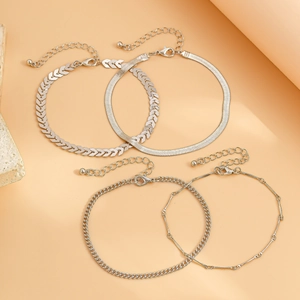 Detailed close-up of four silver anklet sets including snake and curb chain designs