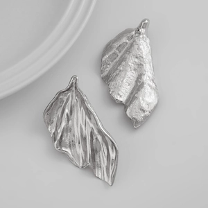 Dettaglio di orecchini a foglia di ginkgo argento con texture in metallo martellato