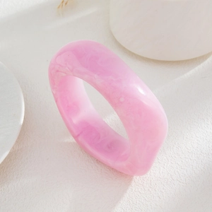Close-up of pink marble texture resin ring with chunky geometric translucent design