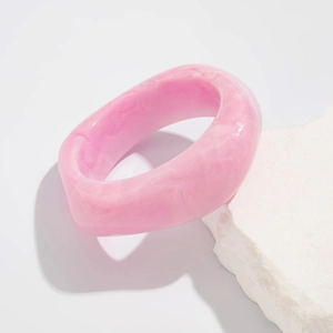 Detail of pink marble textured resin bangle with irregular geometric thick edges