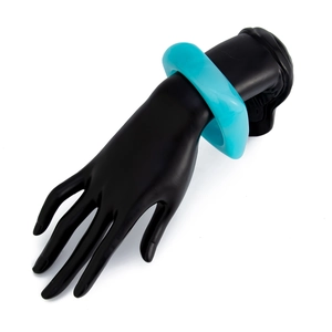 Close-up of a wide bright blue acrylic cuff bracelet on a black hand model