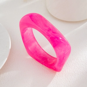 Detailed macro view of translucent rose pink acrylic bangle with marble texture pattern