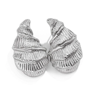 Detailed macro shot of silver conch shell earrings featuring intricate spiral textures