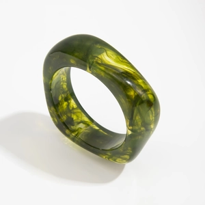 Detailed view of translucent dark green acrylic bangle with marble-like texture