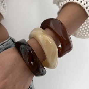 Irregular chunky acrylic resin bangles in tortoise and cream for a layered modern look