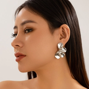 Zilveren bloemoorbellen op model met oversized bladontwerp en gepolijste afwerking
