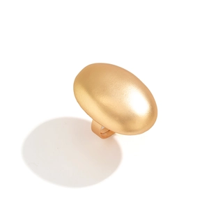 Detailed close-up of a large oval matte gold ring with textured metallic finish