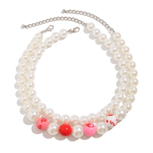 Detail der zweilagigen Perlenkette mit rosa Lippenperlen und roten XOXO-Gravuren
