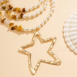 Detail van kralenketting met imitatieparels, turkooisstenen en een gehamerde gouden sterhanger
