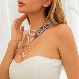 Detailweergave van gelaagde ketting met parels, kleurrijke stenen en een grote zilveren ster