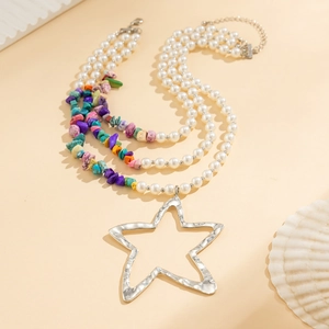 Detail van Boheemse gelaagde ketting met kleurrijke stenen, parels en een grote ster hanger