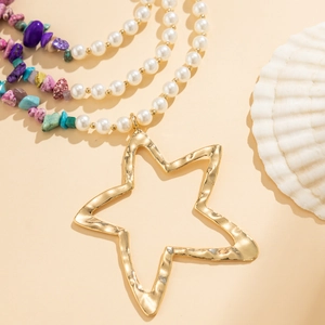 Detail van een gelaagde bohemian ketting met imitatierparels en gekleurde stenen
