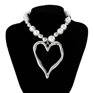Detail of irregular silver lava heart pendant on white pearl and silver bead necklace