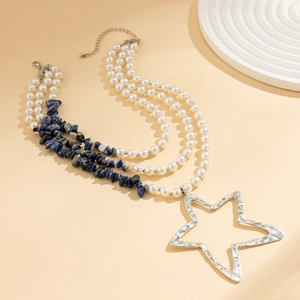 Detail van de gelaagde ketting met blauwe stenen, parels en gehamerde sterhanger