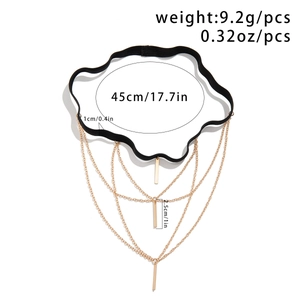 Detail view of punk leg chain with black elastic band and three-layer gold tassel chains