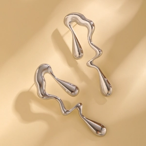 Dettaglio macro degli orecchini in metallo liquido argento con finitura a specchio