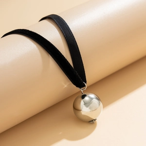 Detailed macro view of black velvet choker with a large polished silver ball pendant