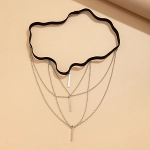 Detail of punk leg chain featuring black elastic band with silver metal fringe tassels