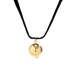 Detail of a large gold polished sphere pendant on a black velvet necklace cord