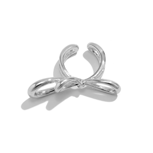 Macro detail of the silver bow ring showing high-polished metallic texture and fluid design