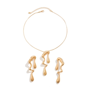 Dettaglio del set di gioielli in metallo liquido dorato con collana e orecchini