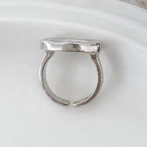 Detailed macro view of the irregular hammered texture on this silver open metal ring