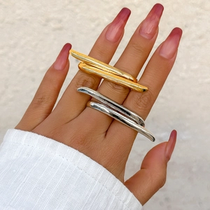 Detailed view of layered metallic rings in gold and silver finish worn on fingers