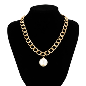 Detailed macro view of a large white faux pearl pendant on a thick gold-tone chain necklace