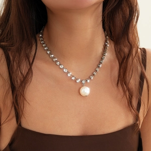 Close-up of elegant multilayer pearl necklace with a large round pearl pendant on a model