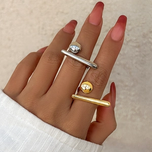 Detailed close-up of polished silver and gold geometric ball rings on model's fingers