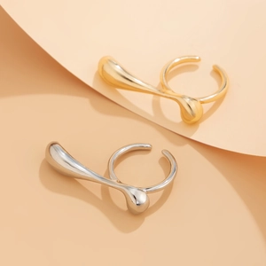Detailed close-up of gold and silver irregular liquid metal rings with smooth glossy texture
